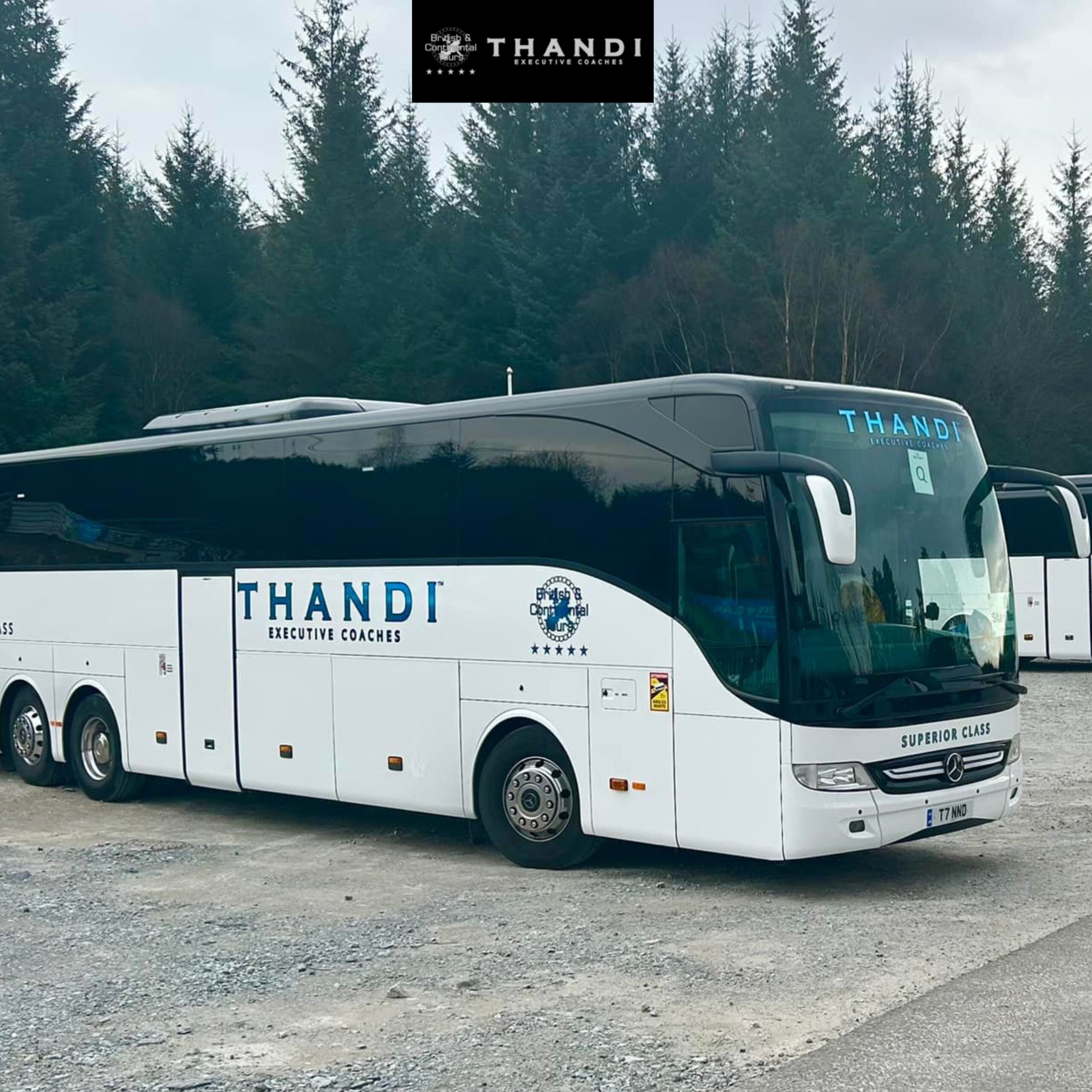 Luxury executive coach bus parked roadside with festive holiday decorations.