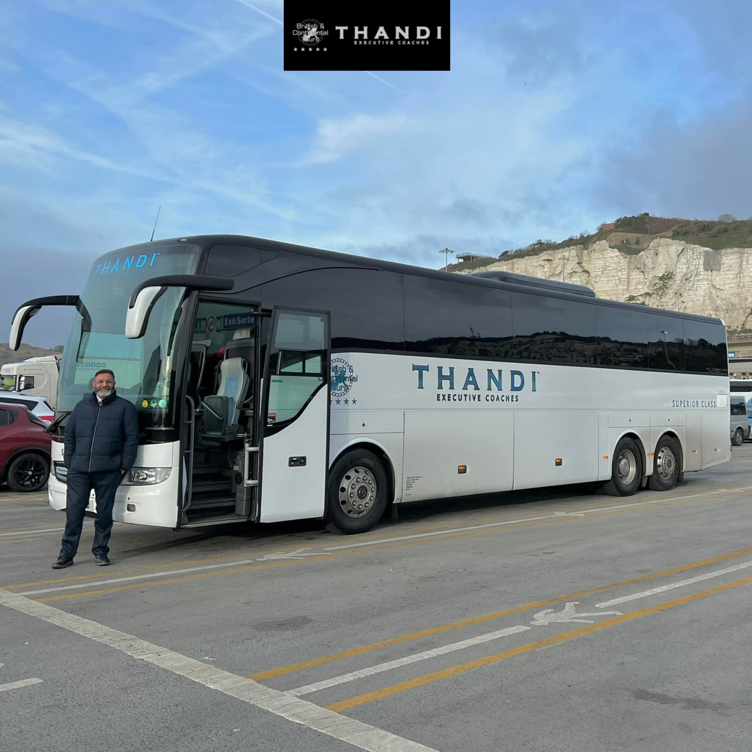 THANDI Executive Coaches luxury white coach parked at port terminal